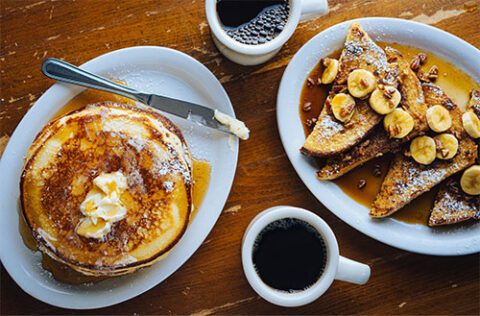 Pancakes, French toast, and coffee on a table.