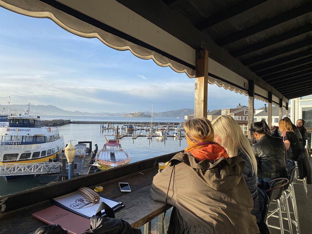 People sitting on the outdoor deck looking over the san francisco bay